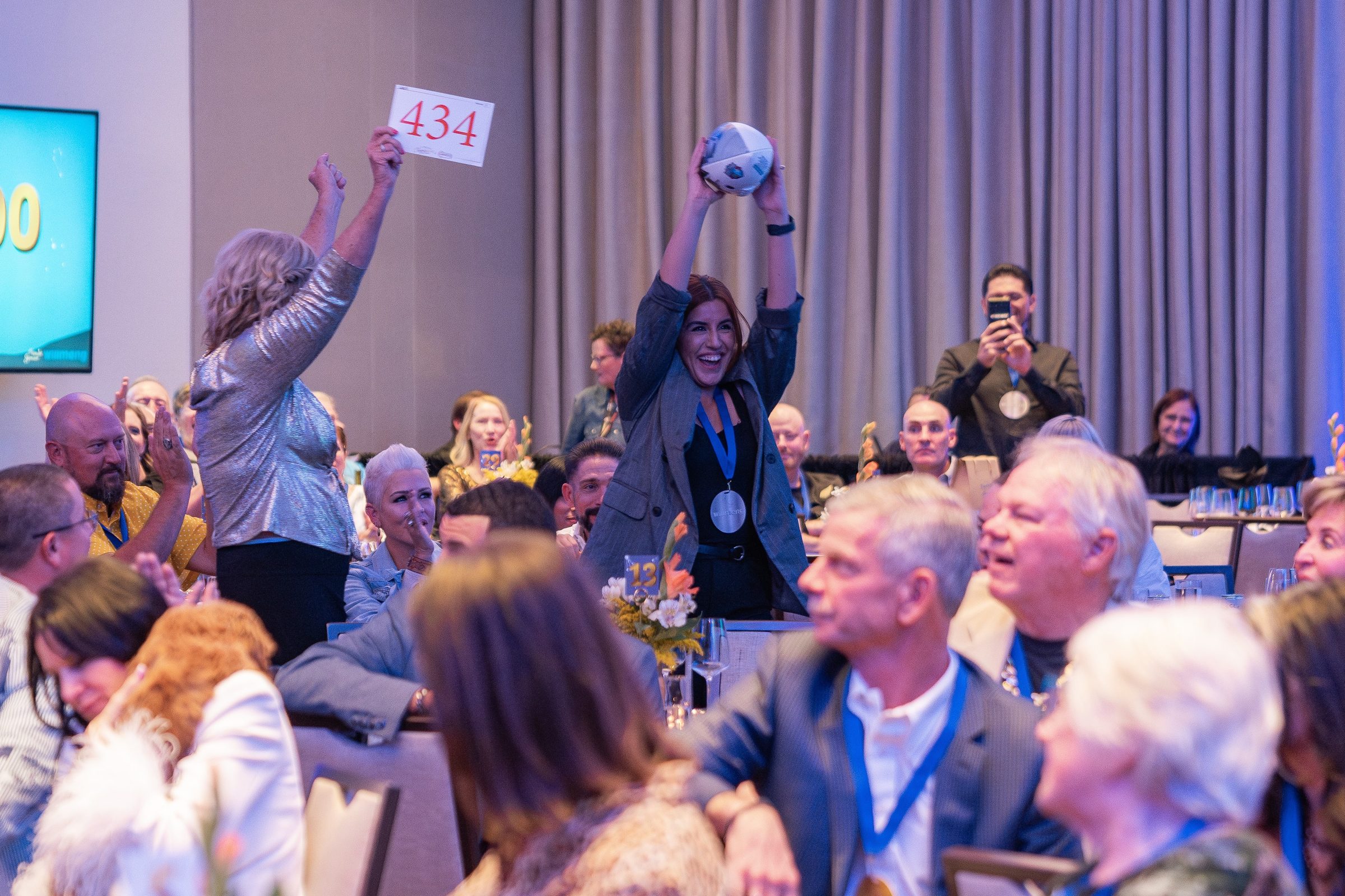 Guests raising their paddles during a Treasure House auction